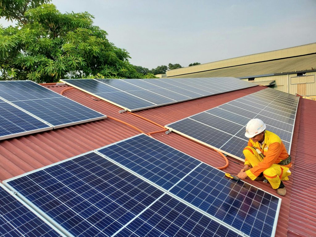 pexels-photo-14613940-14613940 A solar technician performs maintenance on rooftop solar panels enhancing energy efficiency.